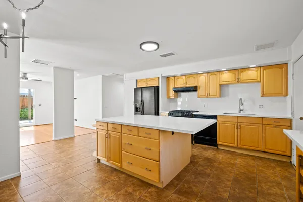 a large kitchen with stainless steel appliances granite countertop a sink and cabinets