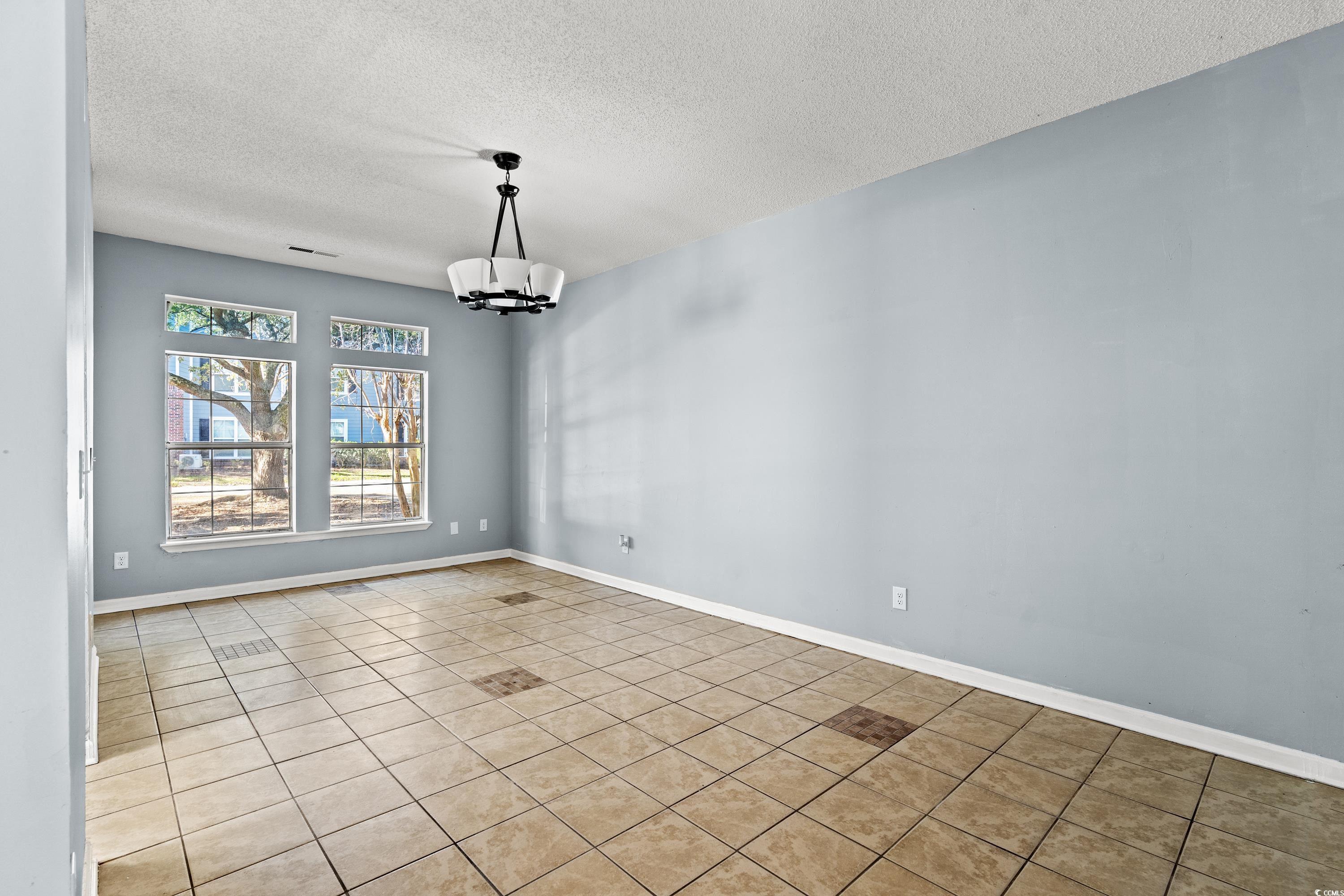 1024 Futrell Drive, Unit 1024 Myrtle Beach, SC 29577 - Photo 16 of 20 Unfurnished dining area featuring a textured ceili
