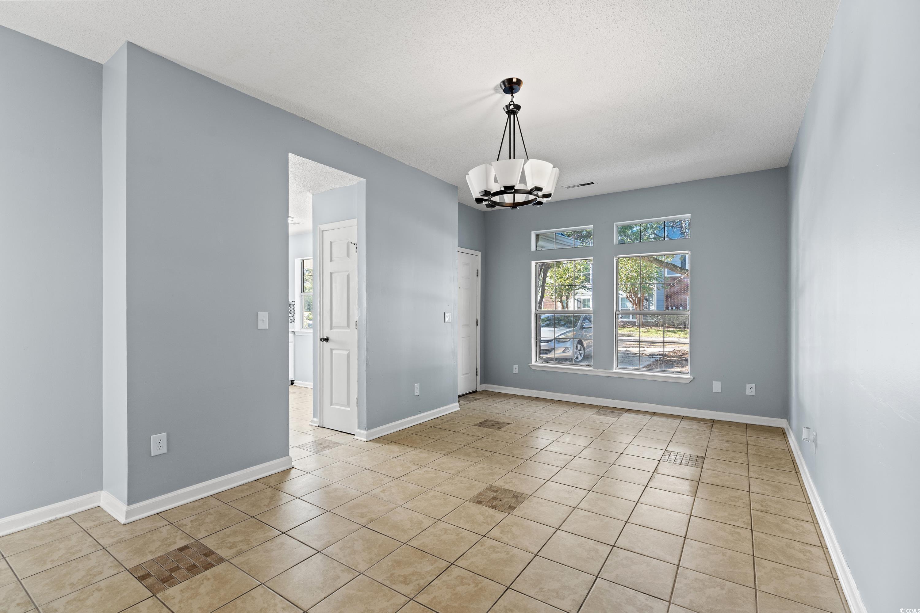 1024 Futrell Drive, Unit 1024 Myrtle Beach, SC 29577 - Photo 17 of 20 Empty room featuring a chandelier, light tile patt