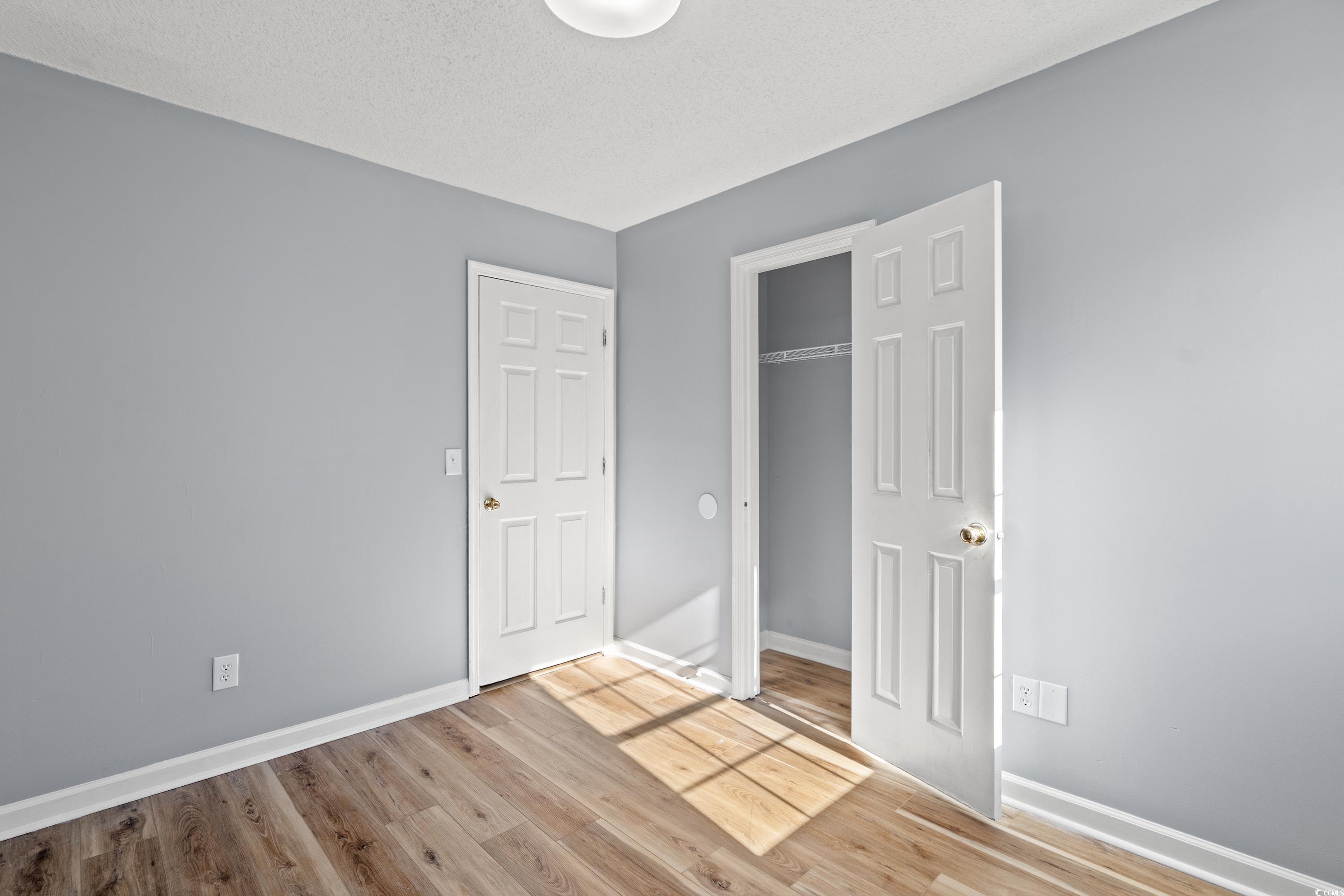 Unfurnished bedroom featuring a closet, light hard