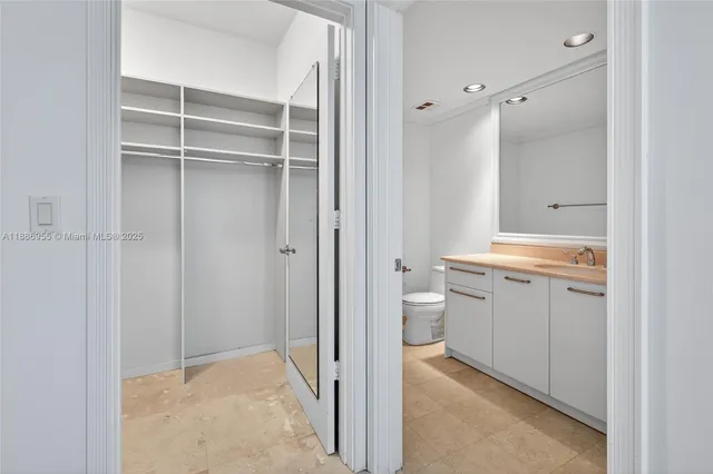 a view of a kitchen with kitchen island stainless steel appliances refrigerator stove dining table and chairs
