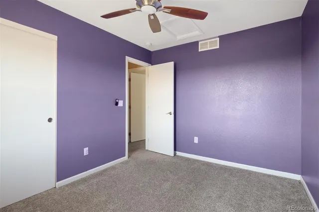 an empty room with a ceiling fan and fan