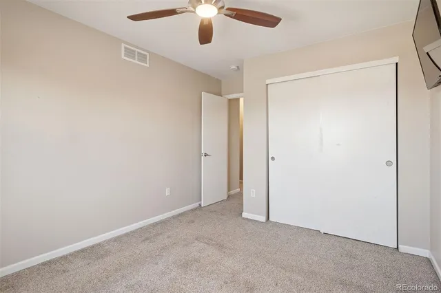 an empty room with a ceiling fan and a window