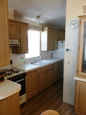 a kitchen with sink a stove and cabinets