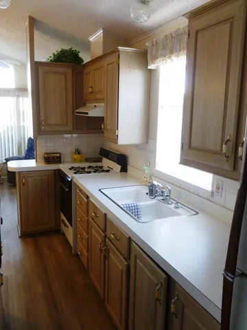 a kitchen with stainless steel appliances granite countertop a sink stove and cabinets