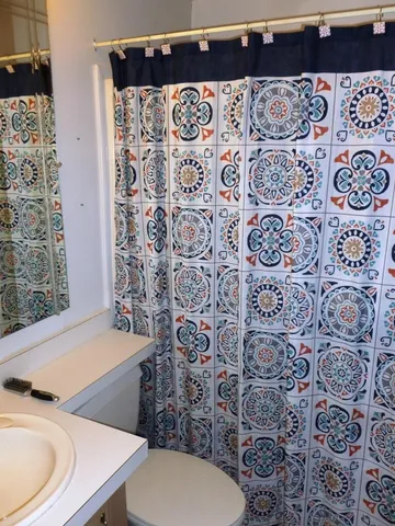 a bathroom with a toilet and a shower curtain