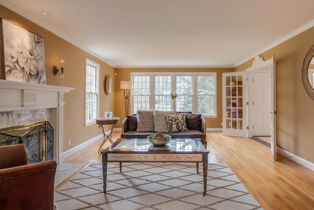 4 Paddock Lane Andover, MA 01810 - Photo 17 of 42 a living room with furniture a fireplace and a floor to ceiling window