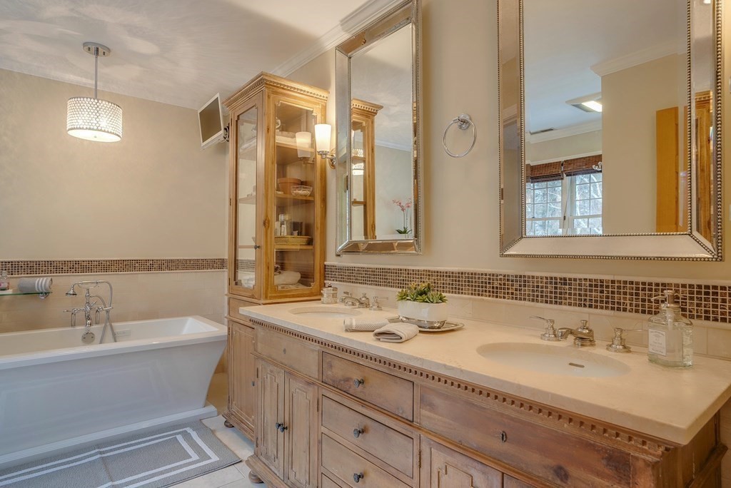 4 Paddock Lane Andover, MA 01810 - Photo 27 of 42 a bathroom with a double vanity sink a mirror and a bathtub