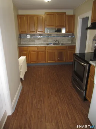 a kitchen with granite countertop a stove a sink and a refrigerator