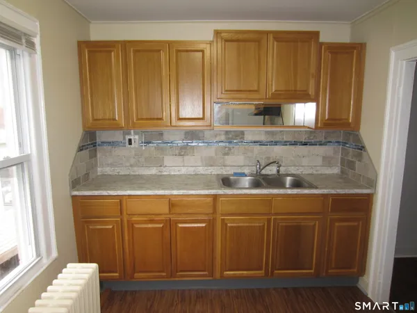 a kitchen with granite countertop a sink cabinets and window