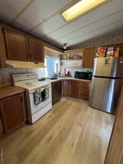 a kitchen with stainless steel appliances granite countertop a refrigerator a stove a sink dishwasher and a refrigerator