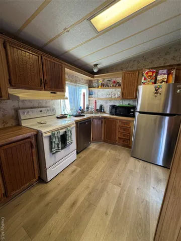 a kitchen with stainless steel appliances granite countertop a refrigerator a stove a sink dishwasher and a refrigerator