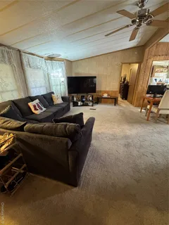a living room with furniture a flat screen tv and a window