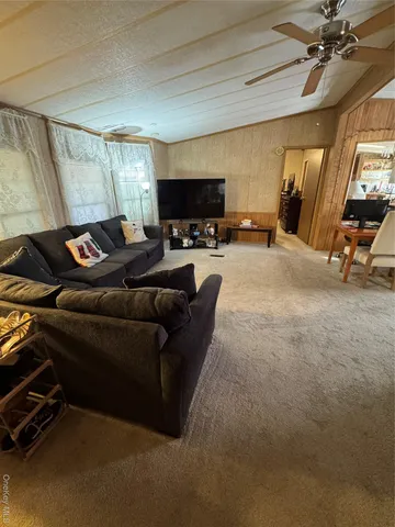a living room with furniture a flat screen tv and a window