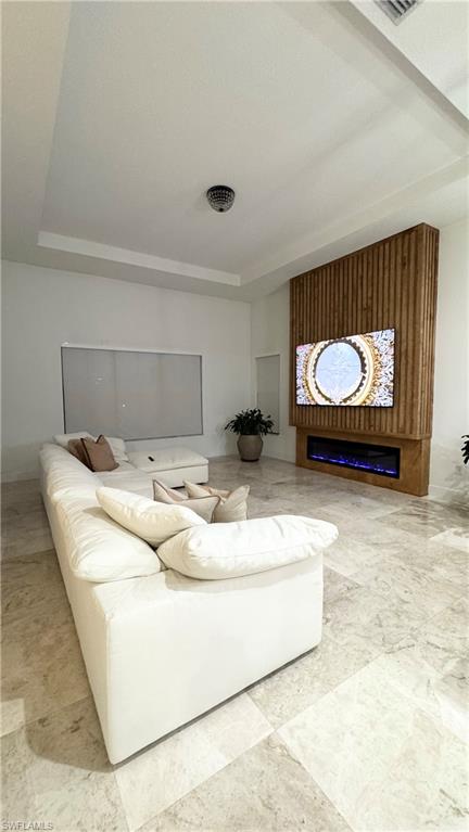 5340 Allen Place Ave Maria, FL 34142 - Photo 13 of 35 Living area with a tray ceiling and a glass covered fireplace