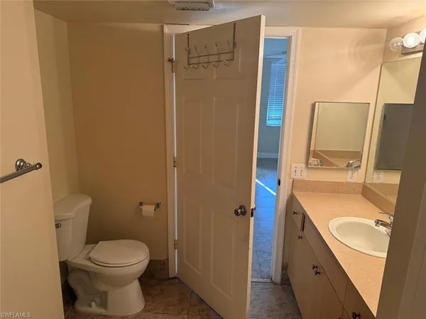 a bathroom with a toilet a sink and mirror