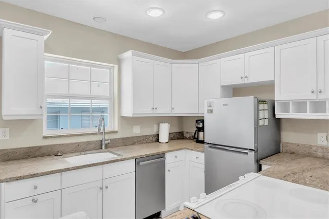 a kitchen with a refrigerator a sink and cabinets