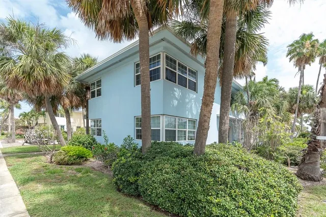 a view of a white house with a palm trees