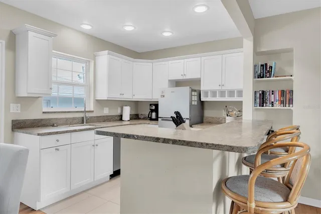 a kitchen with stainless steel appliances granite countertop a sink a stove a refrigerator a microwave and cabinets
