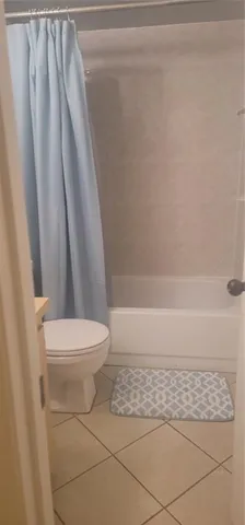 a bathroom with a toilet and a shower curtain
