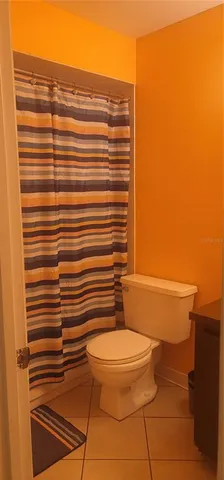 a bathroom with a toilet and a shower curtain