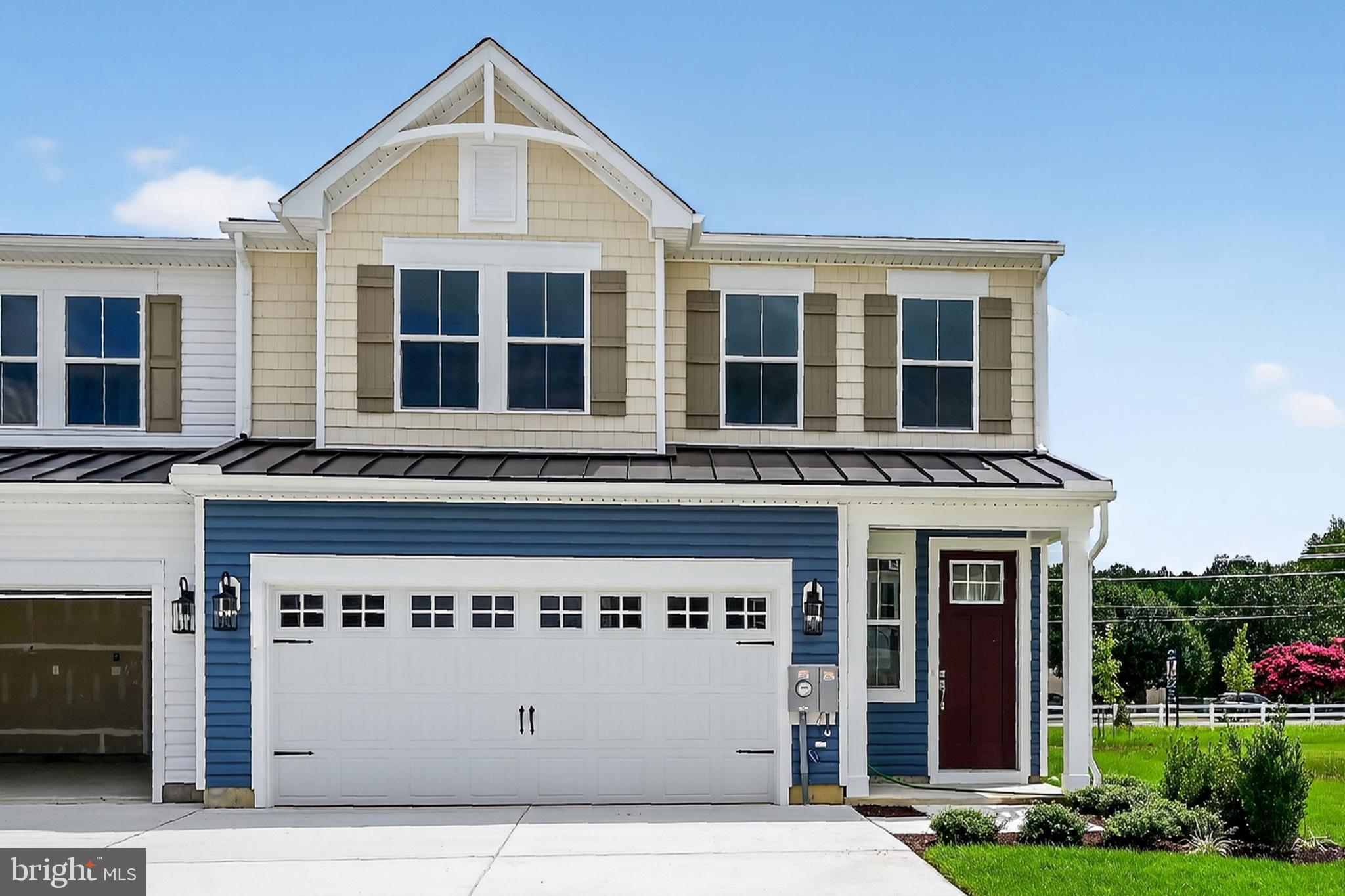 a front view of a building with glass windows and yard