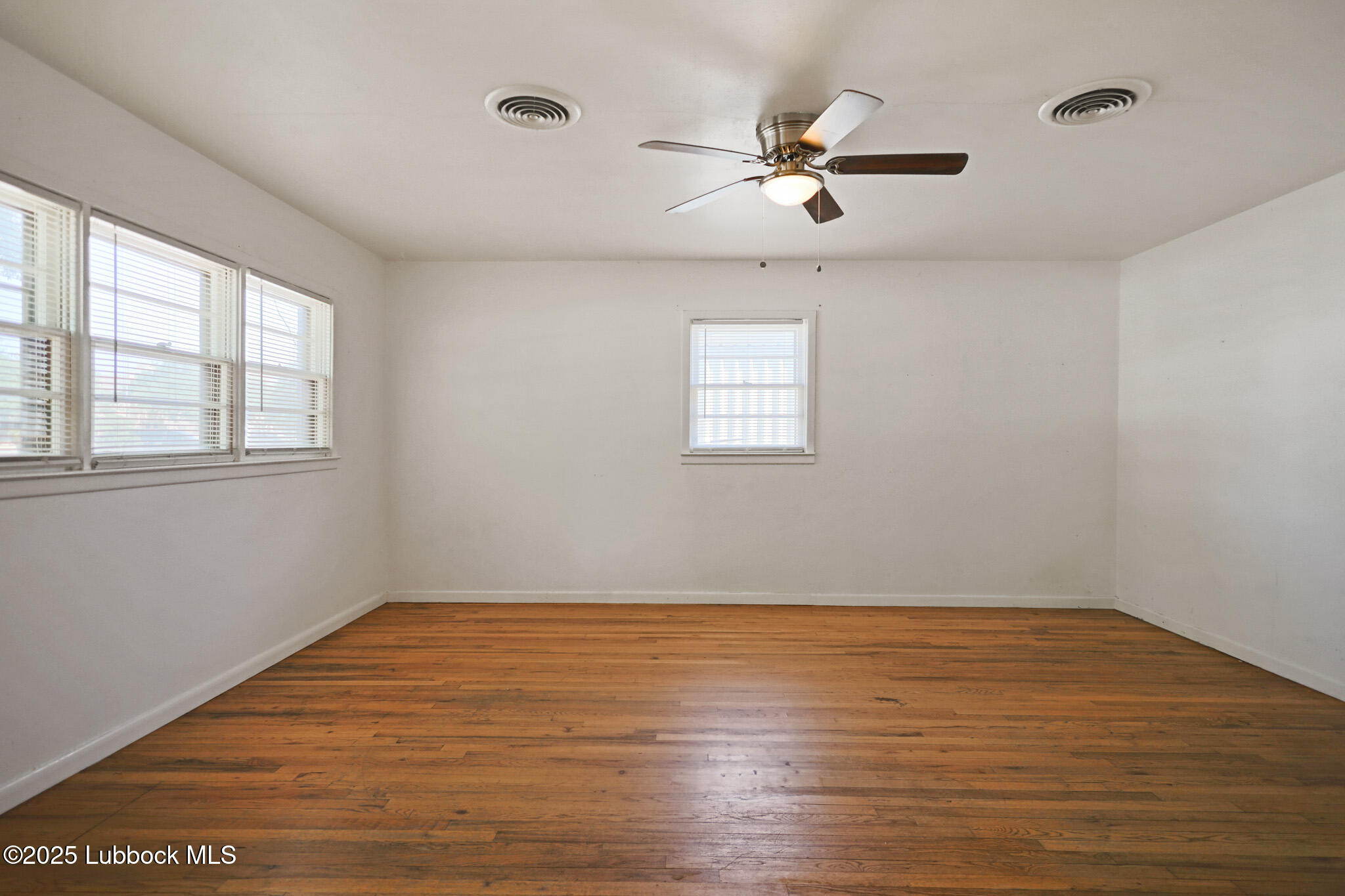 2315 Ithaca Avenue Lubbock, TX 79410 - Photo 6 of 30 wooden floor in an empty room with a window