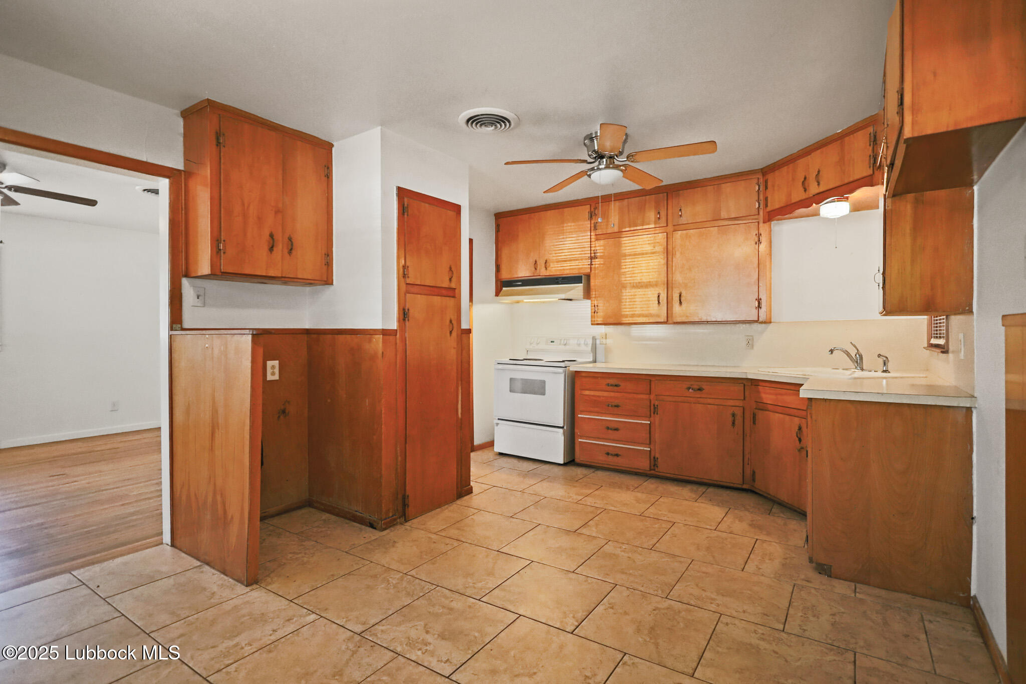 2315 Ithaca Avenue Lubbock, TX 79410 - Photo 10 of 30 a large kitchen with a wooden floor and cabinets