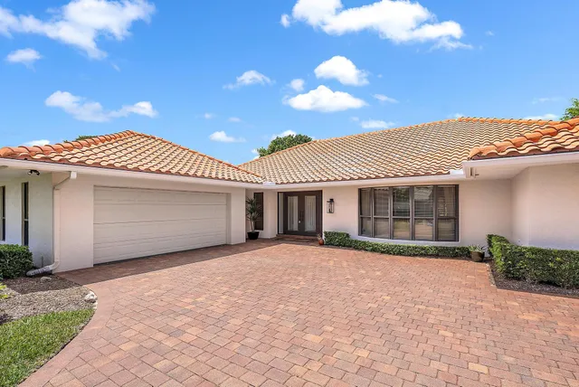 a front view of a house with a garden and yard