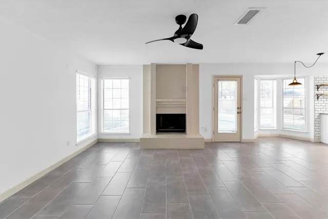 a view of an empty room with a fireplace and a window