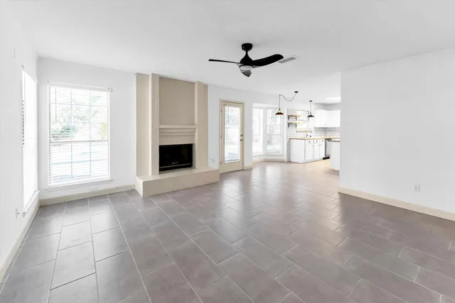 a view of an empty room with a fireplace and a window