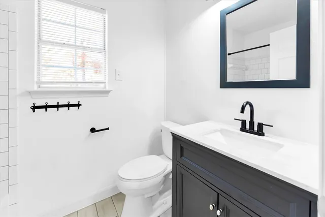 a bathroom with a sink a toilet and a window