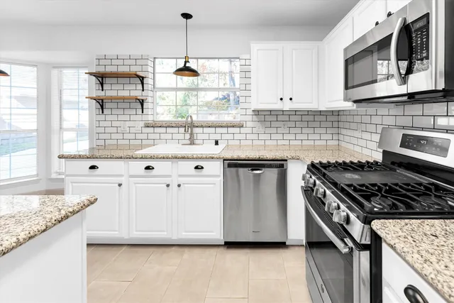 a kitchen with granite countertop a stove and a sink