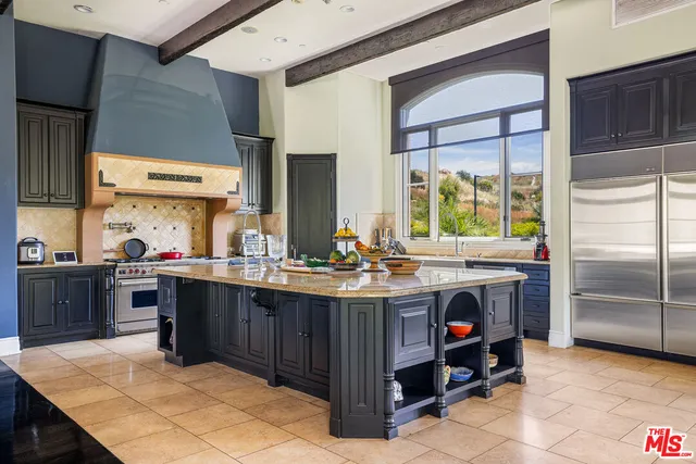 a kitchen with kitchen island granite countertop a sink counter top space and stainless steel appliances