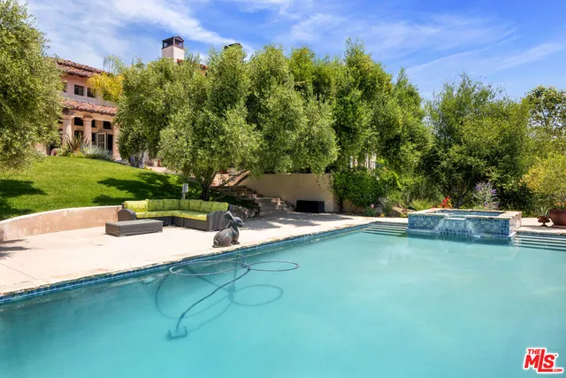 a view of a swimming pool and lounge chairs in the patio