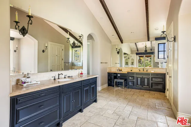 a bathroom with a sink mirror and a shower