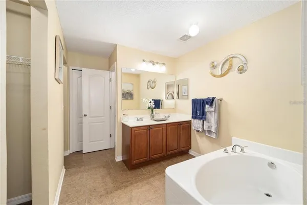a en suite spacious bathroom with a tub double vanity and view bedroom