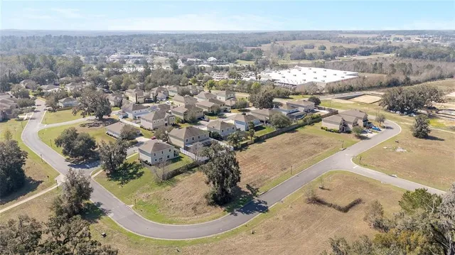 an aerial view of a house with a yard and lake view