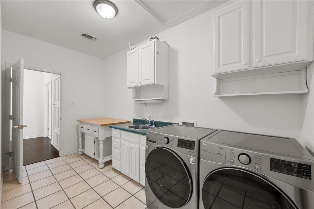 13021 Rudy's Way Streetman, TX 75859 - Photo 28 of 40 Spacious laundry room near Richland Chambers Lake featuring cabinets, sink, tile flooring, and room for full-size appliances.