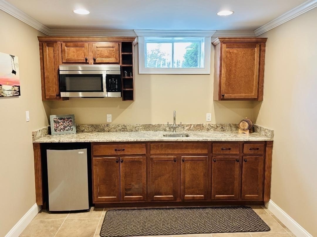 9 Endicott Street, Unit B Danvers, MA 01923 - Photo 28 of 42 a bathroom with a granite countertop sink and a mirror