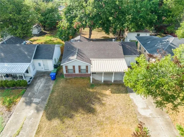 a aerial view of a house with swimming pool and large trees