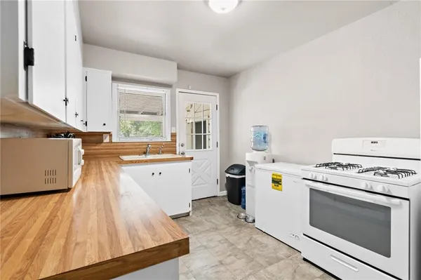 an empty room with chandelier fan and windows