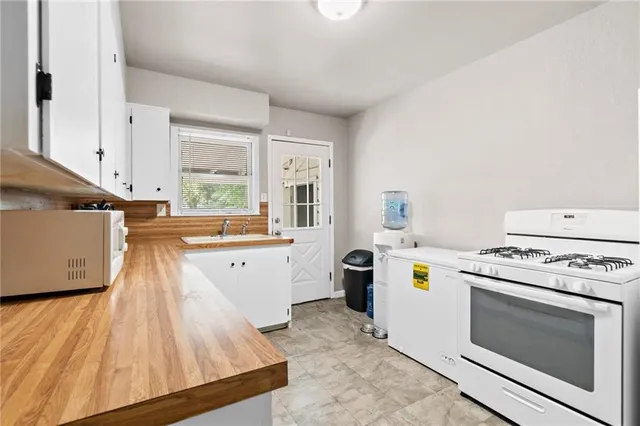 an empty room with chandelier fan and windows