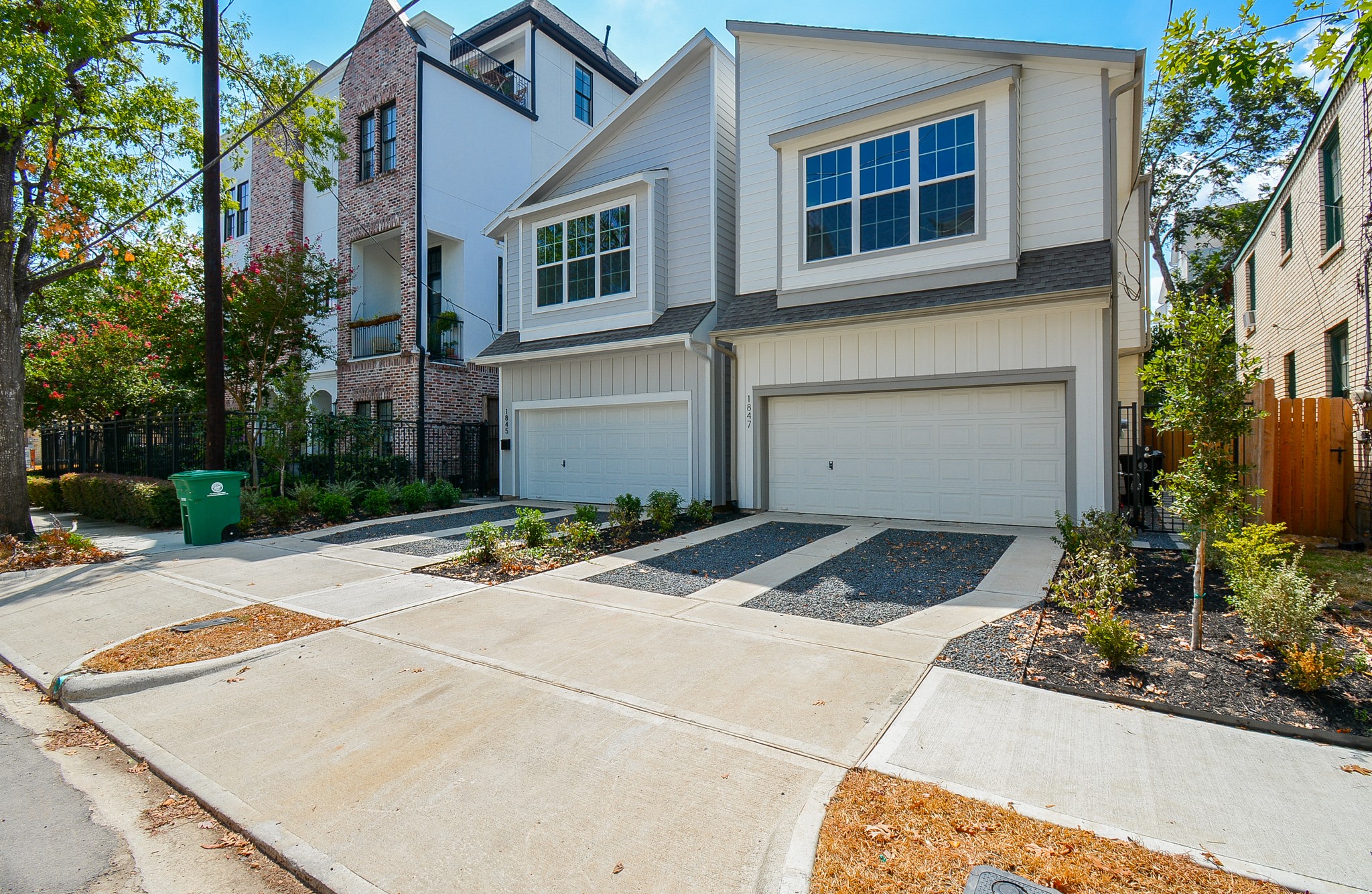 a front view of a house with garage and plants