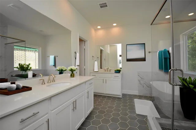 a bathroom with double vanity and a bathtub