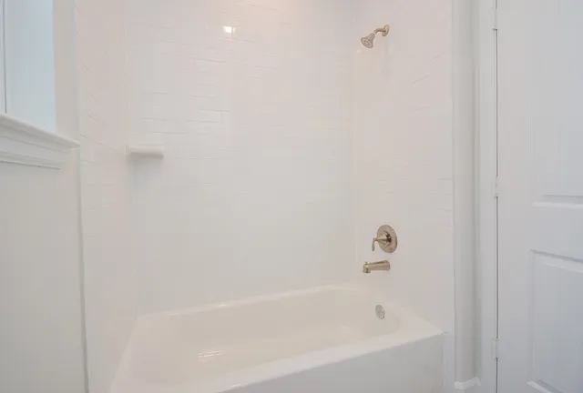 a white bath tub sitting next to a white wall