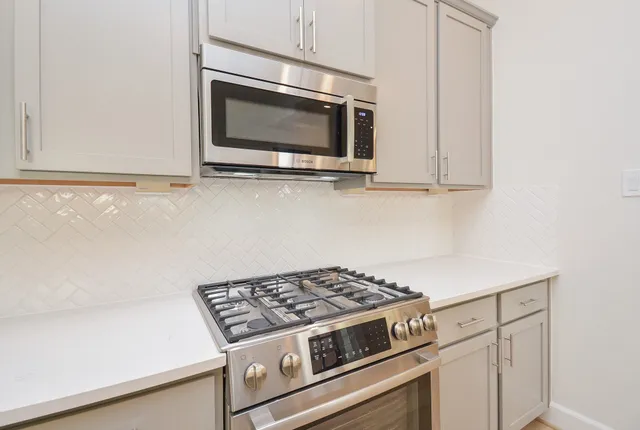 a stove top oven sitting inside of a kitchen