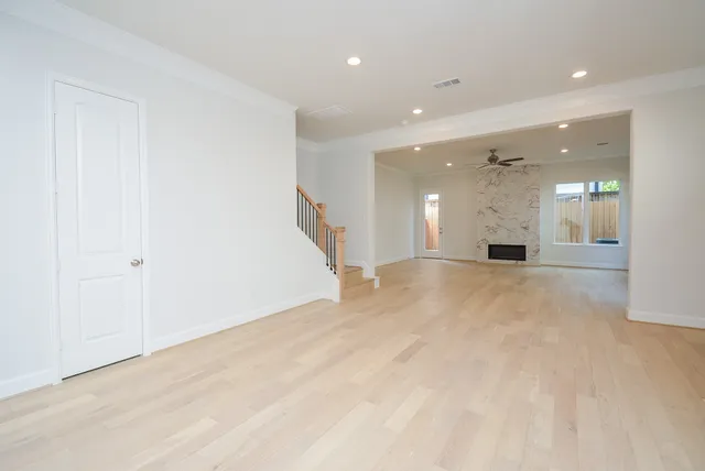 a view of a big room with wooden floor and windows