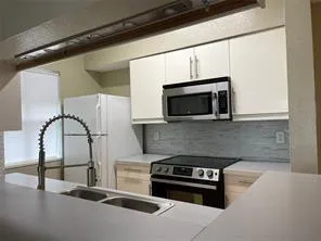 a kitchen with stainless steel appliances kitchen island granite countertop a stove and a microwave