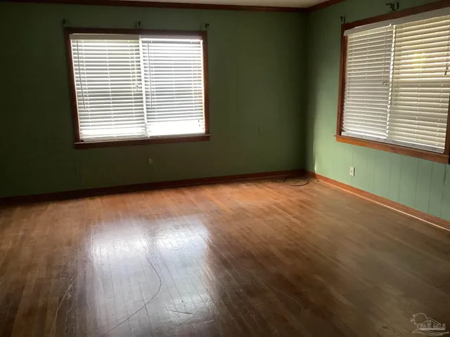 a view of an empty room with wooden floor
